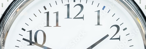 round clock with black arrows and numbers. big clock hanging on a wall. deadline,time management concept and lunch time,WAKE UP.web banner.