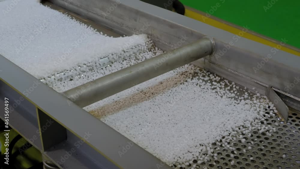 Waste plastic recycling machine: recycled plastic granules - propylene or polyethylene pellets on conveyor belt, shale shaker. Separation, ecology protection, automated technology concept Waste plastic recycling machine: recycled plastic granules - propylene or polyethylene pellets on conveyor belt, shale shaker. Separation, ecology protection, automated technology concept