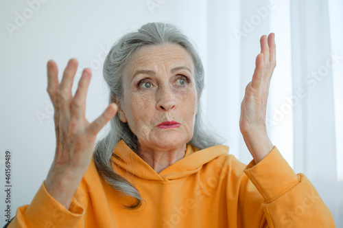 Fotografi Closeup portrait of angry upset senior mature woman talking with someone and looking at the camera