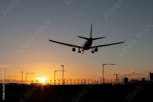 Landing passenger plane during sunset.