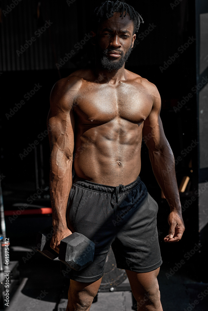 powerful black athletic men pumping up muscles workout bodybuilding concept. muscular bodybuilder handsome man doing exercises with dumbbell in gym, with naked torso fitness and bodybuilding workout
