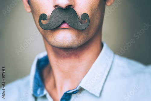 close up of a man's chin wearing a fake paper made mustache - Movember 