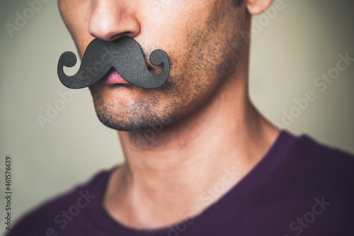 close up of a man's chin wearing a fake paper made mustache - Movember  photo