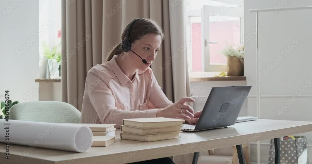 Concentrated young woman teacher using laptop and webcam to distant learning. Online tutor wearing headphones and communicating with students. Concept of remote education. Concentrated young woman teacher using laptop and webcam to distant learning. Online tutor wearing headphones and communicating with students. Concept of remote education.