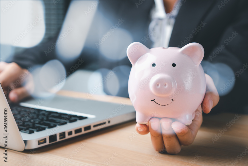 Business woman hand holding piggy bank on wood table, Concept financial business investment, business, finance, investment, financial planning. Business woman hand holding piggy bank on wood table, Concept financial business investment, business, finance, investment, financial planning.