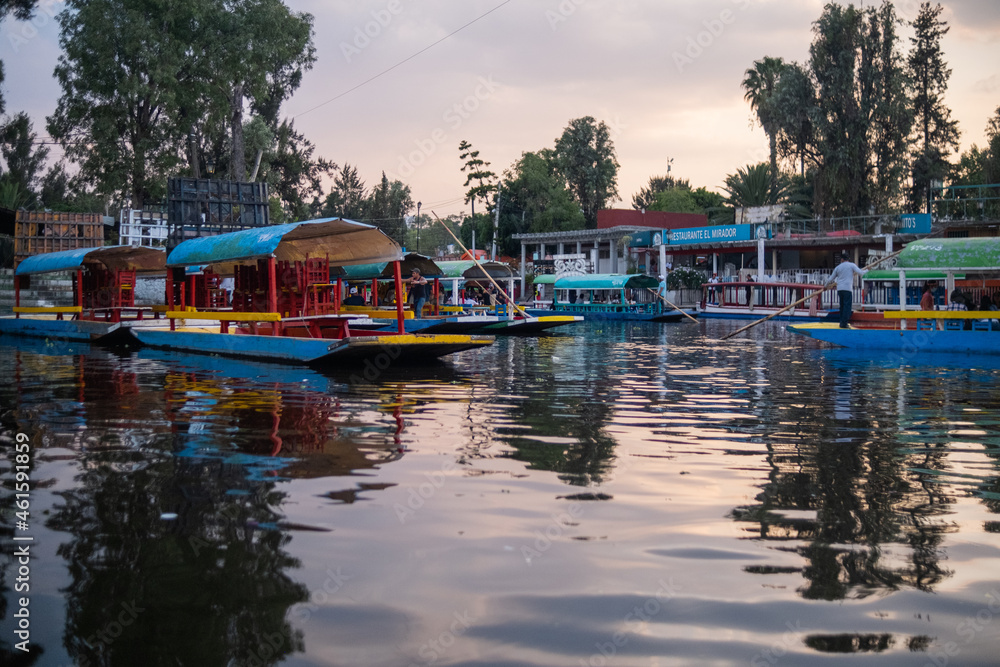 Traditional colorful trajineras in Xochimilco lake under beautiful sky