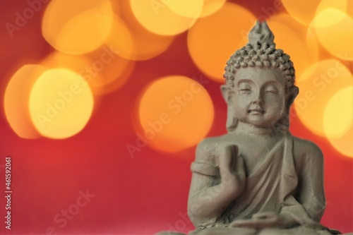 Buddha on red background with golden bokeh .Meditation and relaxation symbol.Buddhism religion background.