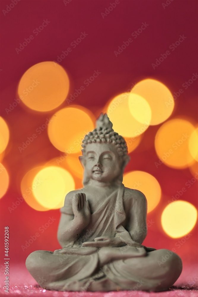 Buddha statue on red background with golden bokeh .Meditation and relaxation symbol. Buddha statue on red background with golden bokeh .Meditation and relaxation symbol.