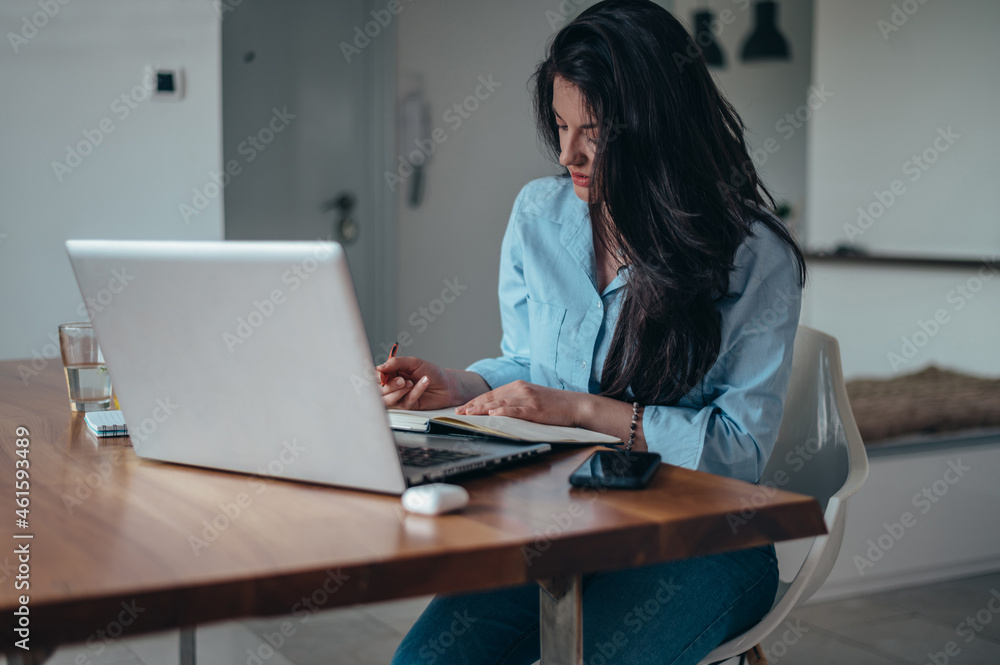 Businesswoman using a laptop while working from home Businesswoman using a laptop while working from home