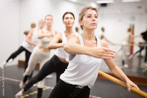 Ballet dancers practicing at barre in the dance class
