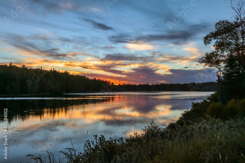 Spectacle Pond near Moosehead Lake  Maine  at sunset with beautiful cloudscape colors