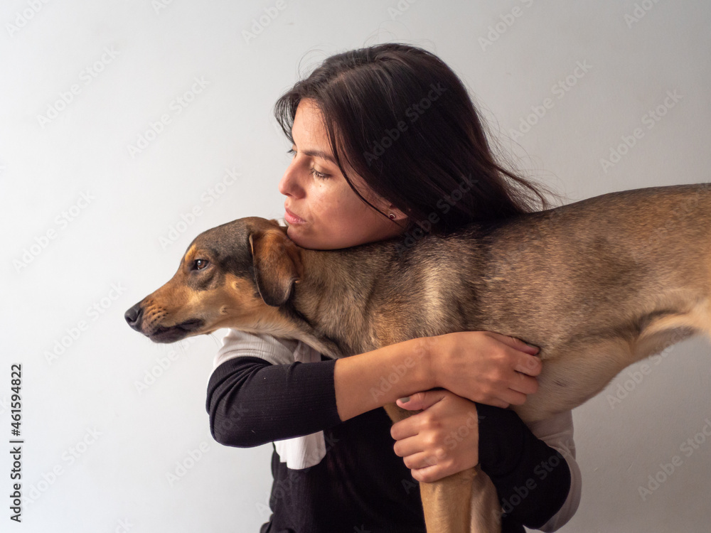 Young Handsome Brown Hair Peruvian Woman Looks Sad While Shes Caresses a Lovely Young Brown Dog
