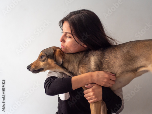 Obraz na płótnie Young Handsome Brown Hair Peruvian Woman Looks Sad While Shes Caresses a Lovely Young Brown Dog w salonie