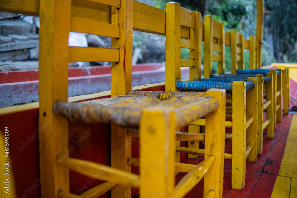 Rustic yellow and blue wooden chairs with blurry background Rustic yellow and blue wooden chairs with blurry background