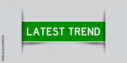 Inserted green color label sticker with word latest trend on gray background