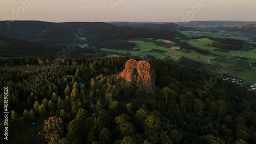 Drone shot wooded mountain and rocky mountains in a pine forest on a sunny evening photo