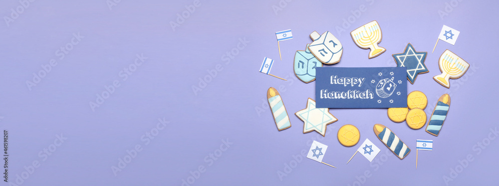 Obraz premium Tasty cookies and greeting card for Hanukkah on color background with space for text