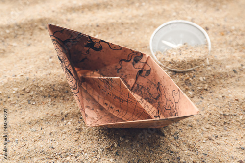 Paper boat and compass on s...