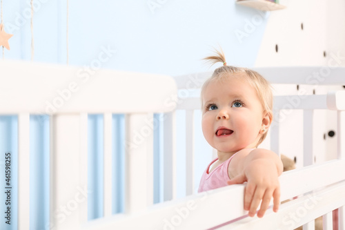 Cute baby girl in cot at home
