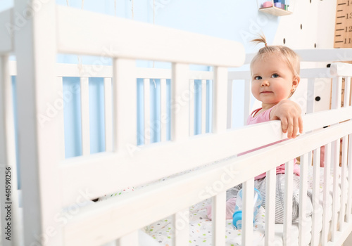 Cute baby girl in cot at home