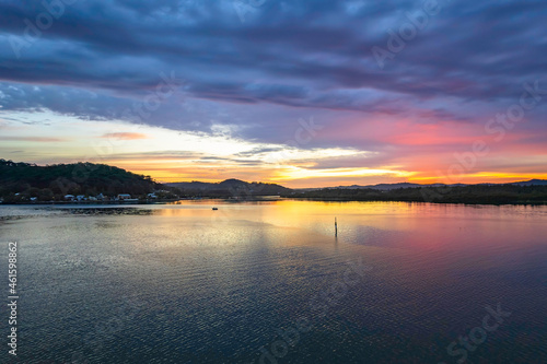 Sunrise waterscape with colourful cloud covered sky