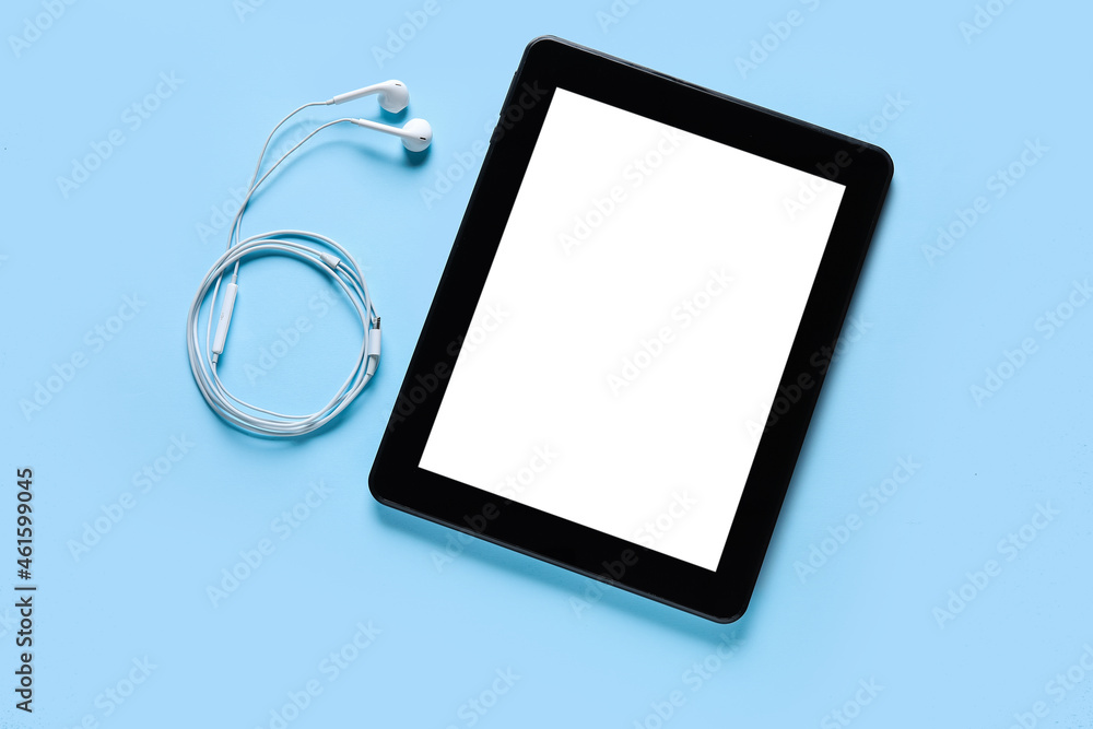 Modern tablet computer and earphones on color background Modern tablet computer and earphones on color background