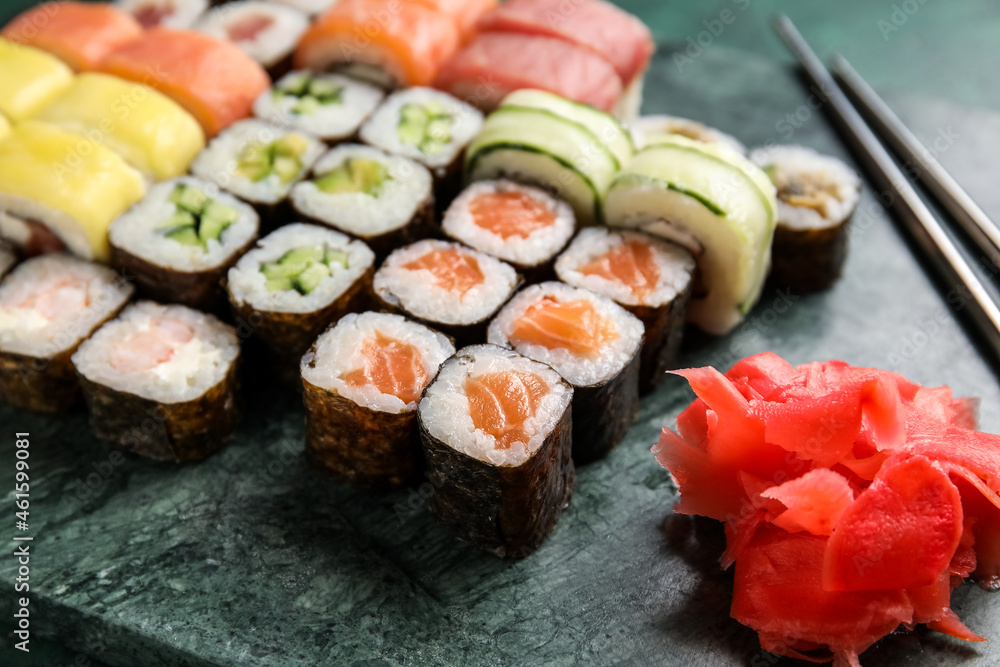Board with set of delicious sushi rolls and ginger, closeup Board with set of delicious sushi rolls and ginger, closeup
