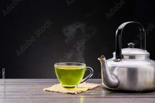 Organic Fresh Green Tea hot green tea placed on wooden table on black background