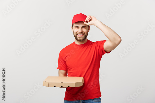 Delivery Concept: Young haapy caucasian Handsome Pizza delivery man holding pizza boxes isolated over grey background photo