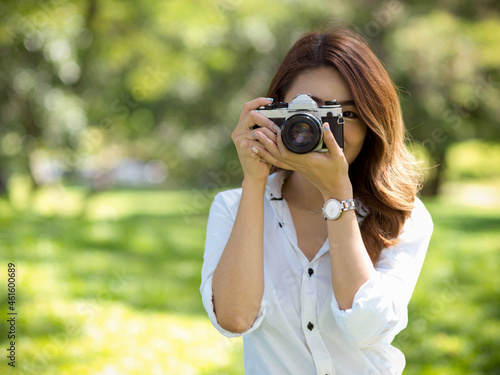 Female photographer taking photo with vintage or retro camera in a park © bongkarn