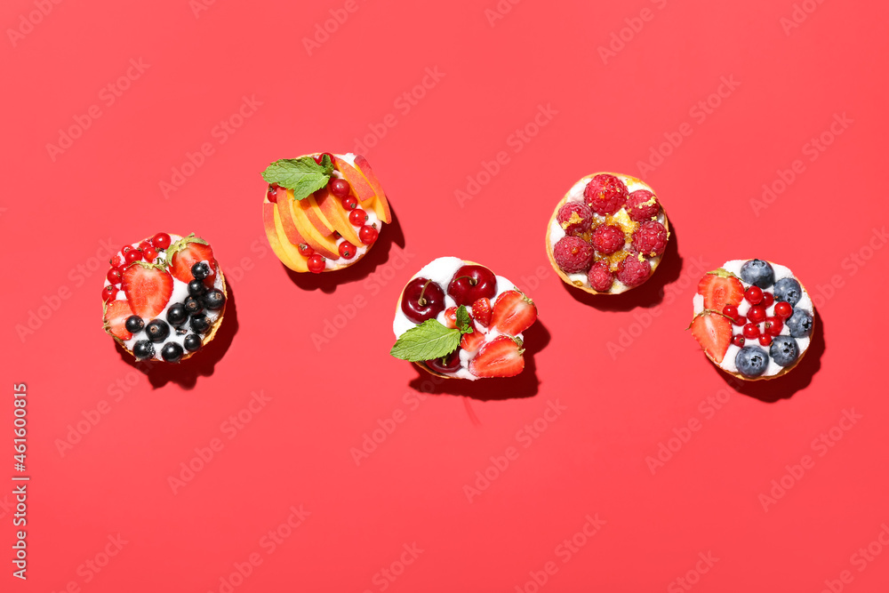 Tasty berry tartlets on color background Tasty berry tartlets on color background