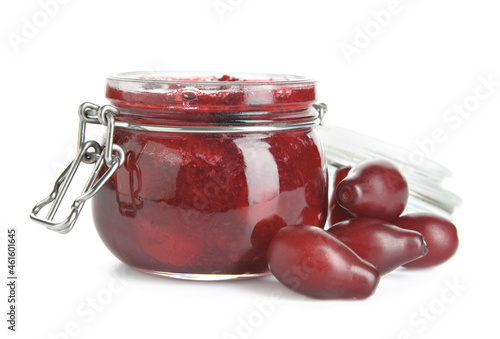Jar of tasty dogwood jam and berries on white background