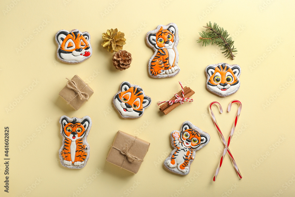 Cute cookies in shape of tiger, gifts and New Year decor on color background Cute cookies in shape of tiger, gifts and New Year decor on color background