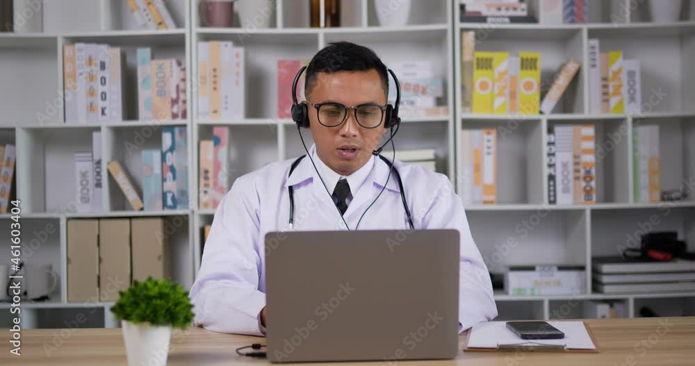 Doctor with headset making conference call on laptop Doctor with headset making conference call on laptop