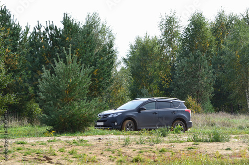 Toyota RAV 4 modern SUV on a dirt country road against the background of an autumn forest