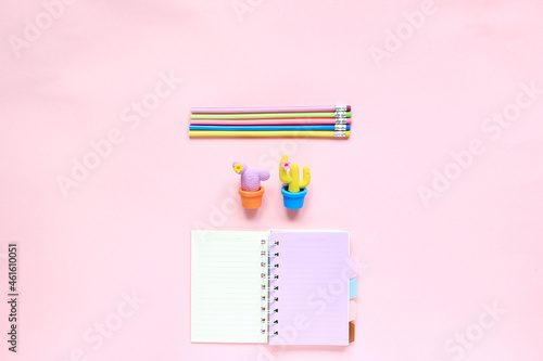 Items for drawing on a pink background. Layout from the sketching kit. Notepad, eraser and pencils on a pink background. View from above photo