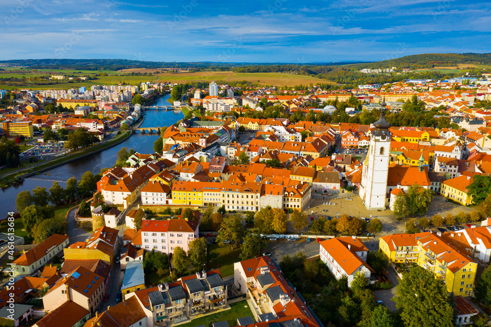 Aerial view of Old Town of Czech city of Pisek on Otava river overlooking white belfry of Church of Nativity 