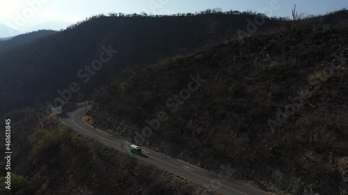 Aerial footage of VW Combi Bus driving through a curvy highway in the desertic mountains of Oaxaca, Mexico. photo