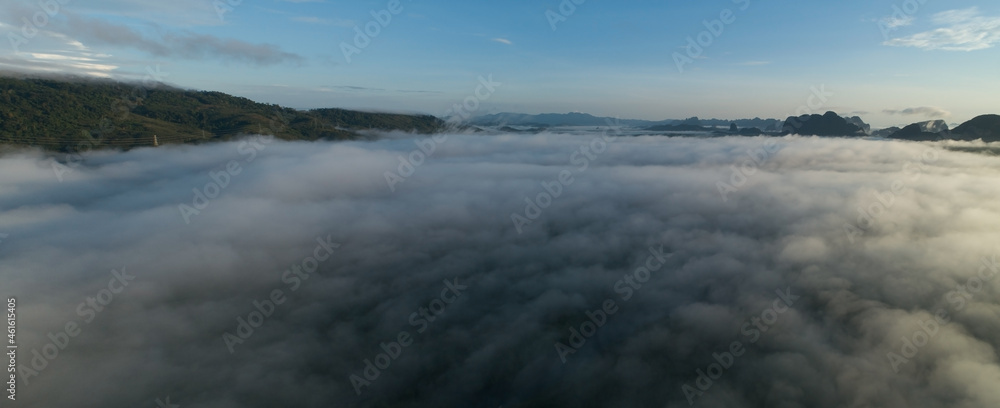 Aerial view Panorama of flowing fog waves on mountain tropical rainforest,Bird eye view image over the clouds Amazing nature background with clouds and mountain peaks in Thailand