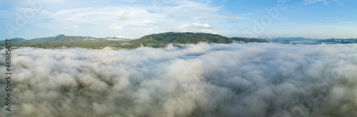 Fototapeta Naklejka Na Ścianę i Meble -  Aerial view Panorama of flowing fog waves on mountain tropical rainforest,Bird eye view image over the clouds Amazing nature background with clouds and mountain peaks in Thailand