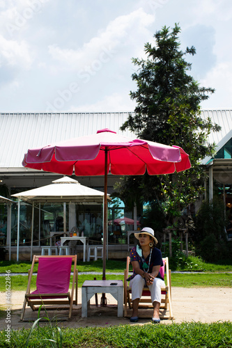 Asian travelers thai women people travel visit and sitting rest relaxed on deck chairs or lounge chair on small beach in garden park outdoor of cafe restaurant coffee shop at Bangkok of Thailand © tuayai