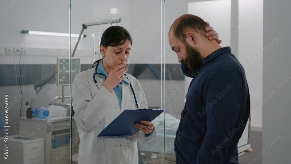 Practitioner woman doctor explaining sickness diagnosis discussing recovery treatment with worried father in hospital ward. Hospitalized sick girl resting in bed during medical consultation Practitioner woman doctor explaining sickness diagnosis discussing recovery treatment with worried father in hospital ward. Hospitalized sick girl resting in bed during medical consultation