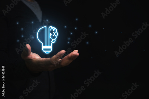 Businessman holding virtual light bulb and half brain on blue bokeh background smart thinking concept and innovative ideas inspired