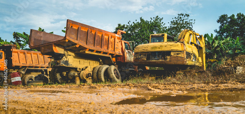 Wreck of heavy machinery in the junkyard of forestry company.  Broken old rusty truck and excavator photo