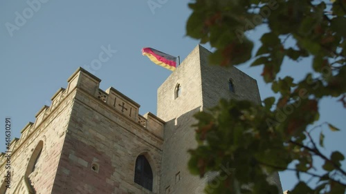 Low Angle Shot of Tower of Hambach Castle through Leaves on Brunch and Blue Sky with German Flag photo