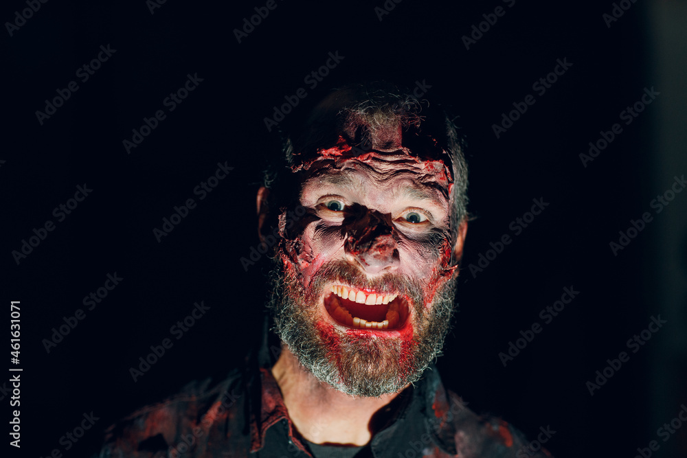 Fototapeta premium Zombie man portrait in darkness with makeup for halloween party