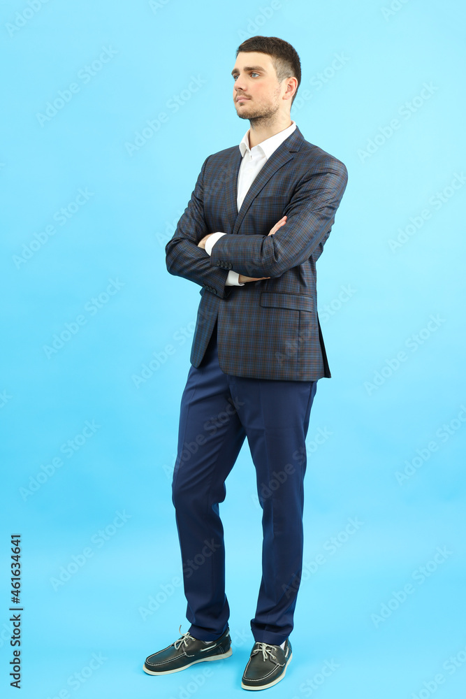 Young businessman in classic suit on blue background Young businessman in classic suit on blue background