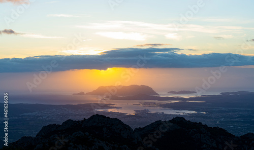View from above, stunning sunrise during a cloudy day with the city of Olbia, the homonymous gulf and Tavolara island in the distance. Panoramic view from Monte Pino, Sardinia, Italy.