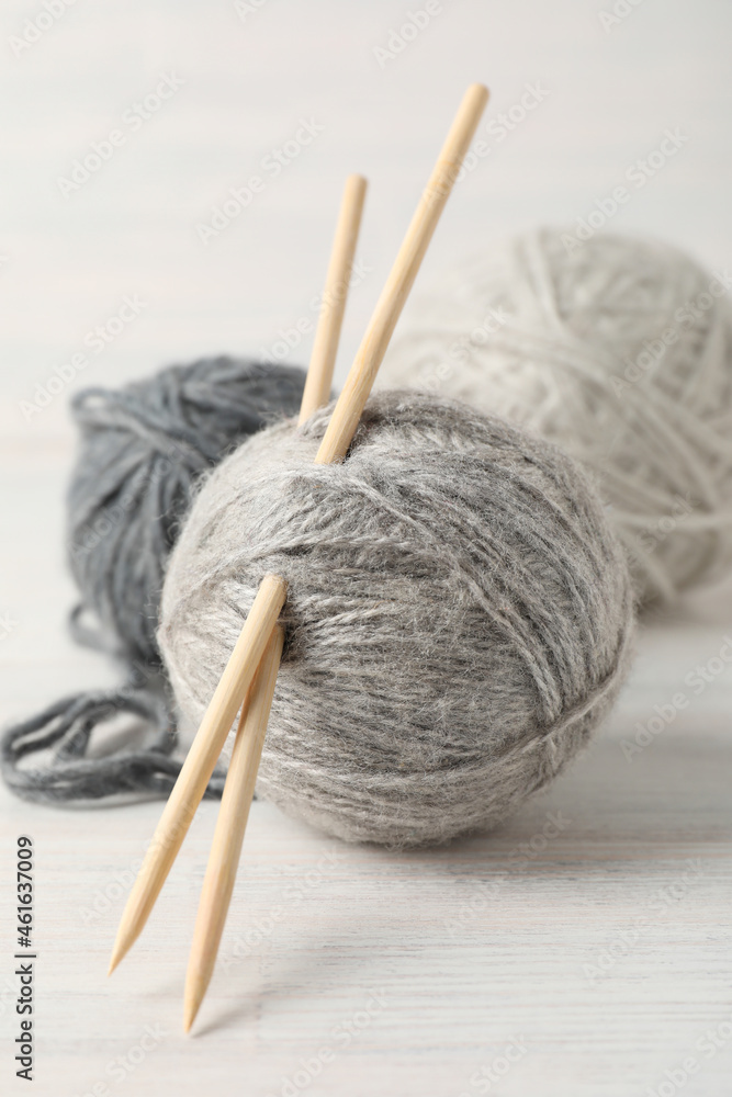 Balls of yarn with knitting needles on white wooden background Balls of yarn with knitting needles on white wooden background