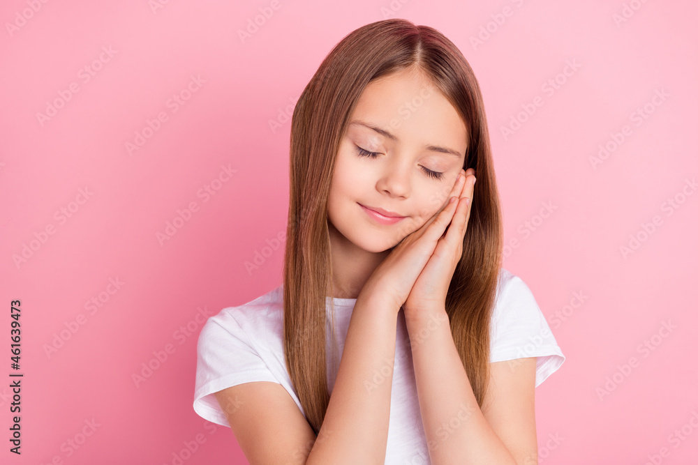 Photo of sleepy blond small girl hold hands wear white t-shirt isolated on pink color background Photo of sleepy blond small girl hold hands wear white t-shirt isolated on pink color background